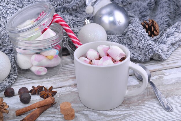 Caneca cheia de marshmallow em um chocolate ao leite em uma mesa na decoração de Natal