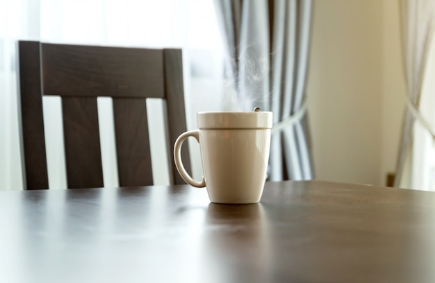 Caneca de café branca em uma mesa de madeira