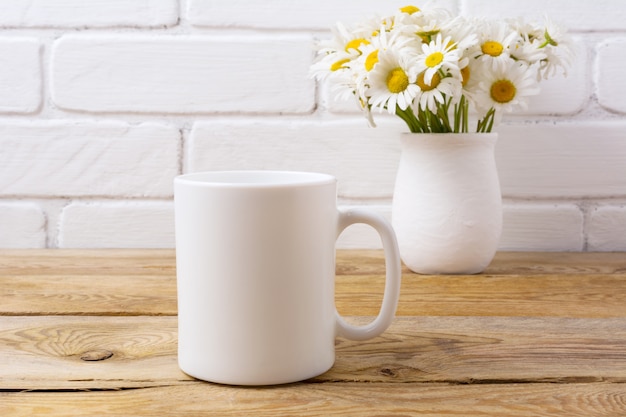 Caneca de café branco com buquê de camomila em vaso rústico