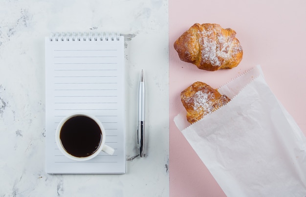 Caneca de café com croissants e caderno vazio e caneta para plano de negócios e idéias de design