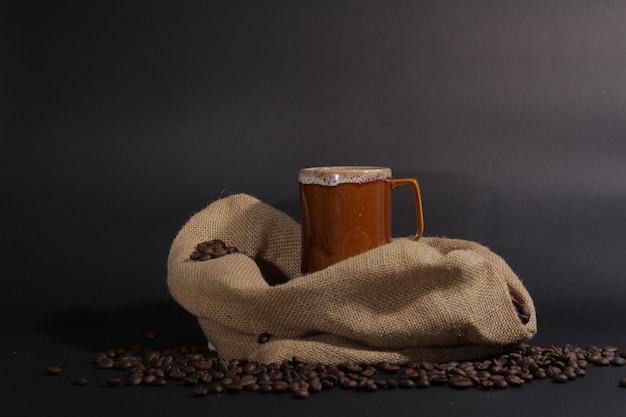 Foto caneca de café com grãos de café e saco de pano