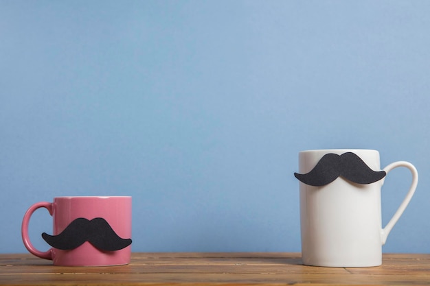 Caneca de café do dia dos pais com bigode de papel contra um fundo azul