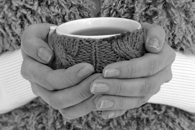 Foto caneca de chá quente nas mãos de mulheres ao ar livre
