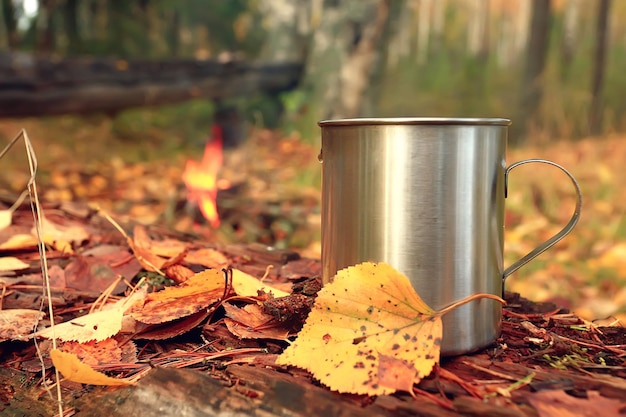 caneca de ferro com chá quente em um acampamento estilo de vida ativo outono parque amarelo
