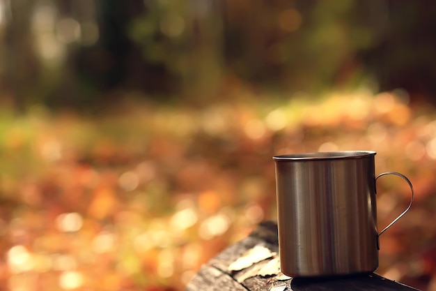 caneca de ferro com chá quente em um acampamento estilo de vida ativo outono parque amarelo