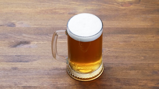 Caneca grande de cerveja gelada saborosa leve em uma mesa de madeira