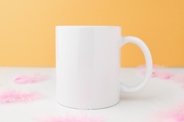 Caneca vazia branca para design e logotipo em um fundo laranja com maquete de decoração de Páscoa com espaço de cópia