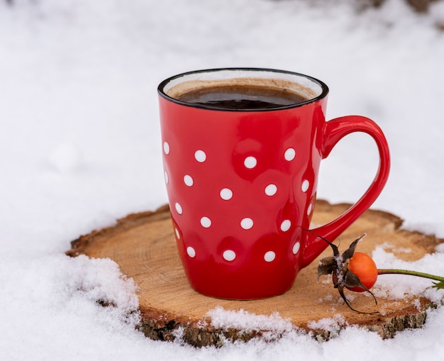 Caneca vermelha em um ponto branco com café preto quente