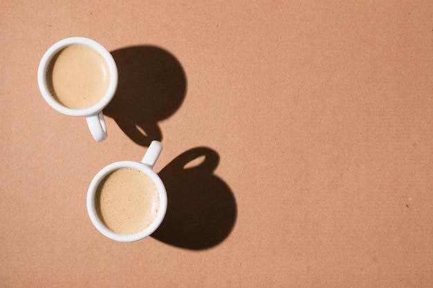 Foto canecas com café quente e sombras