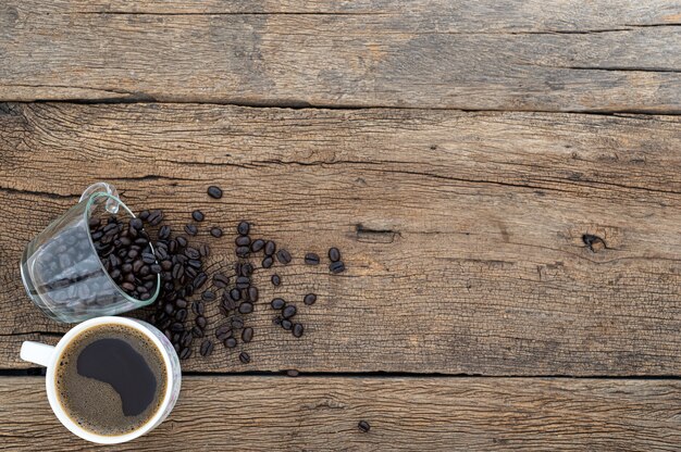 Canecas de café e grãos de café estão na mesa