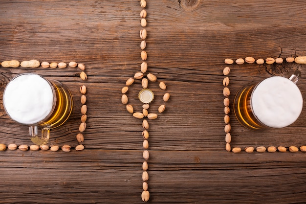 Canecas de cerveja vista superior com fundo de madeira