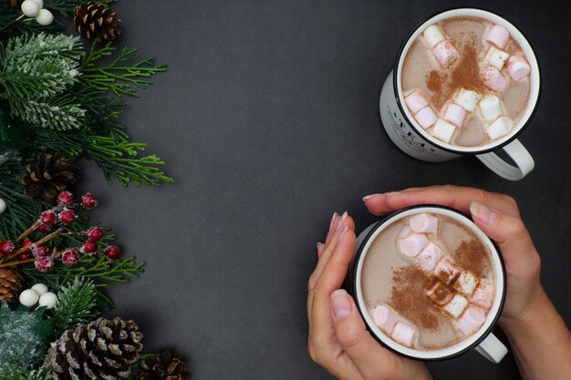 Canecas de chocolate quente com marshmallows e decoração de Natal, plana leigos com ramos de abeto, bebida quente.