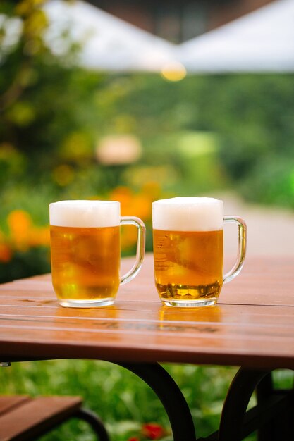 Canecas de vidro de cerveja na mesa no terraço de um café