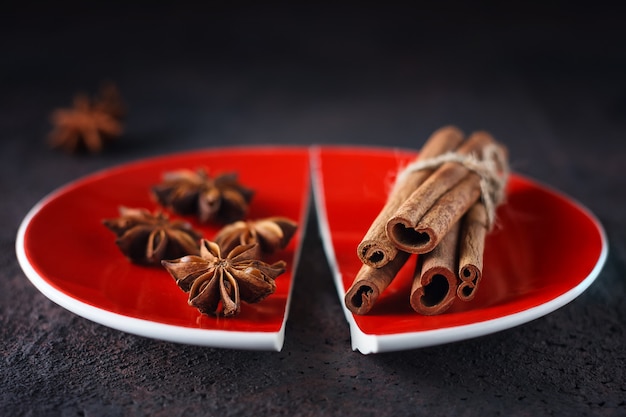 Canela y anís en un plato rojo dividido.