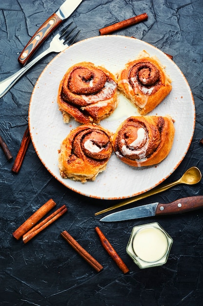 Canela con canela y queso mascarpone Bollos caseros en un plato Rollos de canela o canela