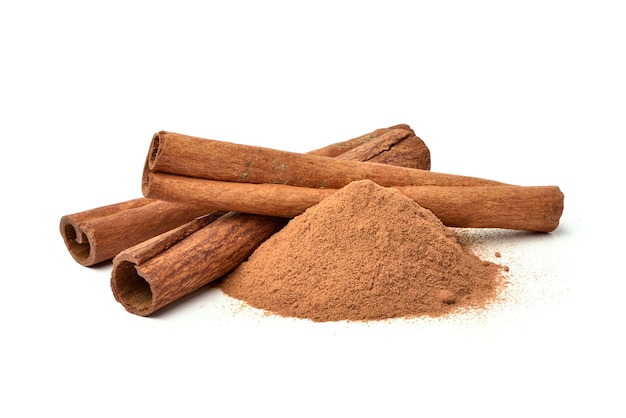 Canela em pó aromático com varas isoladas em branco