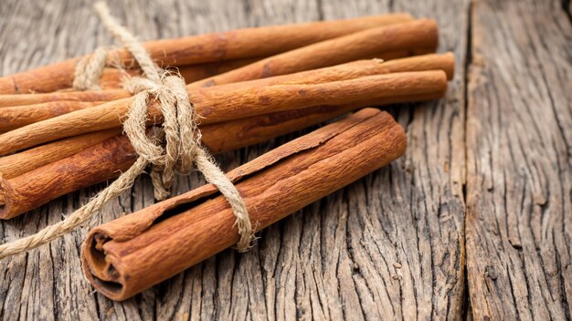 Canela molida palos de canela atados con cuerda de yute sobre un antiguo fondo de madera en estilo rústico Generativo Ai