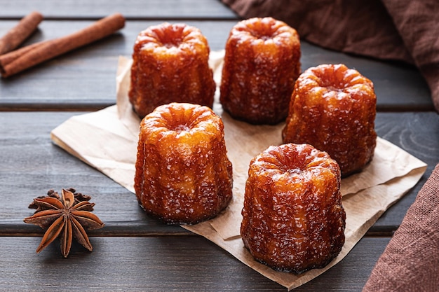 Canele de sobremesa francesa local em um fundo escuro de madeira