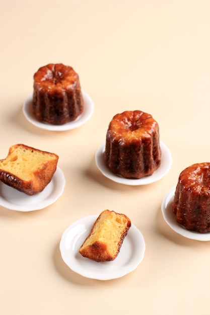 Canele o Cannele, pastelería francesa de Burdeos. Sabores de ron y vainilla con un centro de natillas tiernas y una corteza espesa caramelizada. Servido en un mini plato, fondo negro con espacio de copia