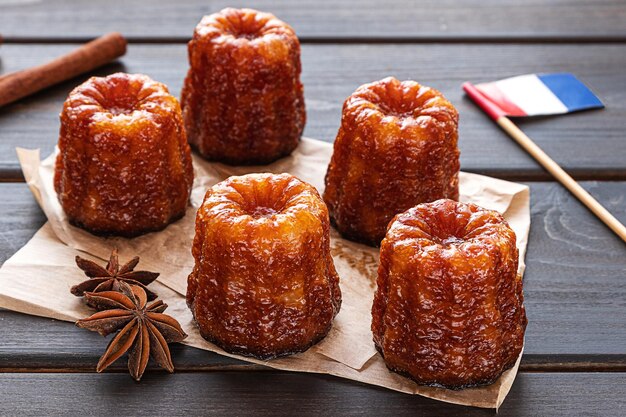 Canele de postre francés local sobre un fondo de madera oscura