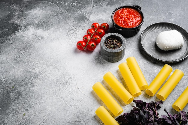 Canelones de cocina italiana con espinacas y ricotta, sobre fondo de mesa de piedra gris, con espacio para copiar texto