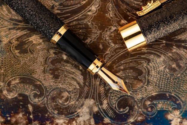 caneta bonita caneta em uma superfície de metal velho com belos ornamentos em relevo foco seletivo