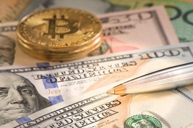 Caneta de closeup no dólar de usd e bitcoin para o conceito de negócio