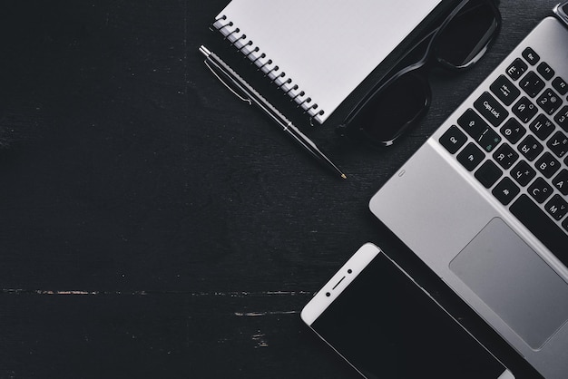 Caneta de notebook Laptop desktop de escritório Em um fundo preto Vista superior Espaço livre para texto Copiar espaço