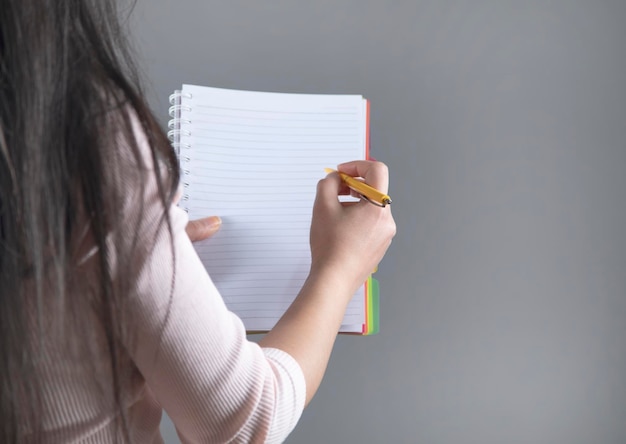 Caneta e bloco de notas da mão da mulher