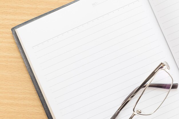 caneta e caderno aberto com página em branco