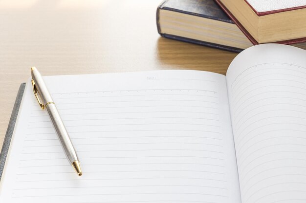 caneta e caderno página em branco aberta