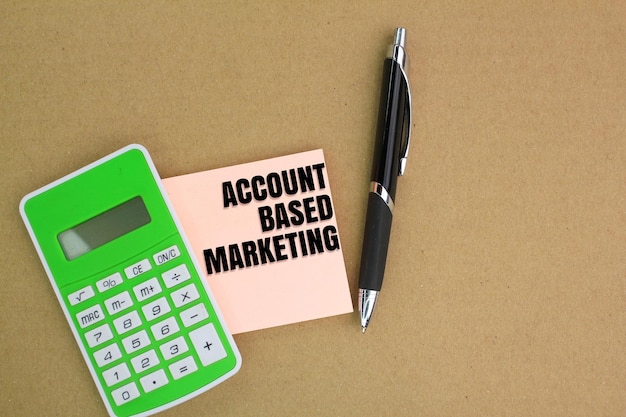 caneta e calculadora com as palavras Account Based Marketing em papel branco