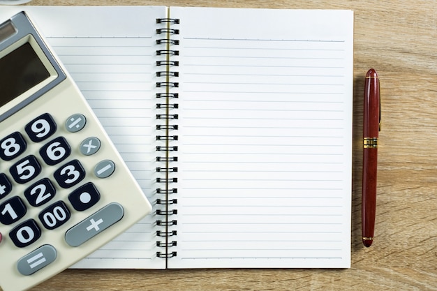 Caneta-tinteiro ou caneta de tinta com papel de caderno e calculadora
