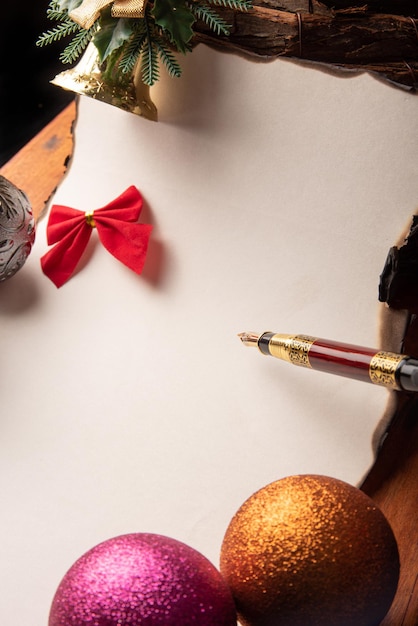 Caneta-tinteiro uma bela caneta-tinteiro uma folha em branco com bordas queimadas e enfeites de Natal Foco seletivo