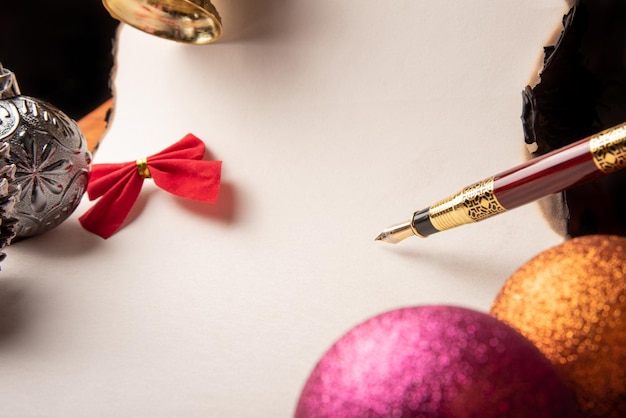 Caneta-tinteiro uma bela caneta-tinteiro uma folha em branco com bordas queimadas e enfeites de Natal Foco seletivo