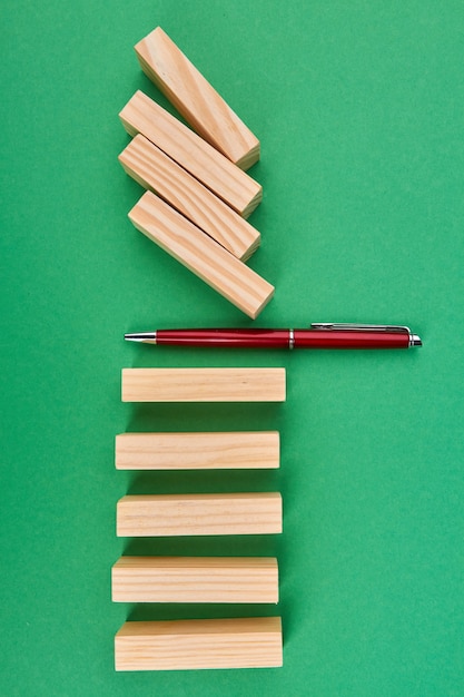 Foto caneta vermelha e blocos de madeira lisos em verde