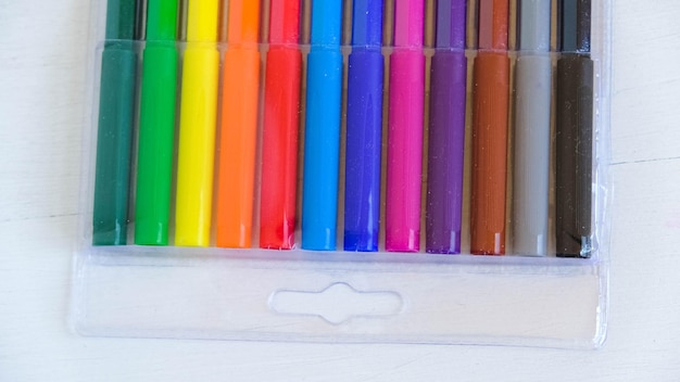 Canetas de feltro multicoloridas em um pacote transparente em um fundo branco