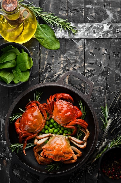 Cangrejos de mar hervidos con verduras en una sartén negra Mariscos Vista superior Espacio libre para el texto