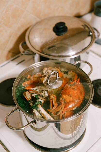 Cangrejos rojos hervidos en una cacerola Los cangrejos azules se cocinan en una cacerola con tapa de vidrio