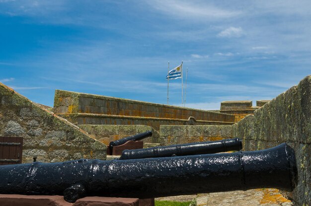 Foto canhão com a bandeira do uruguai ao fundo