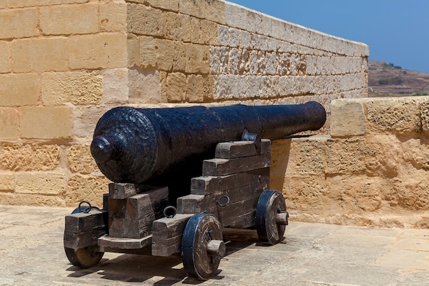 Canhão de ferro fundido preto velho na Cidadela Victoria. A Cidadela Victoria é uma cidade fortificada do bastião de São João, dentro da cidadela de Malta. Ilha de Gozo. Patrimônio Mundial da UNESCO.