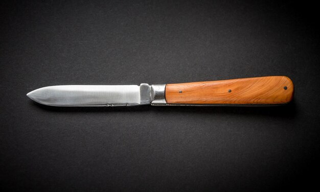 Canivete de madeira tradicional em fundo preto