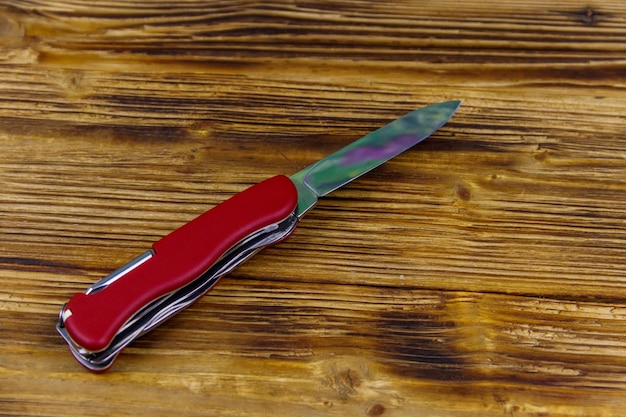 Foto canivete vermelho para todos os fins em um fundo de madeira rústico vista superior