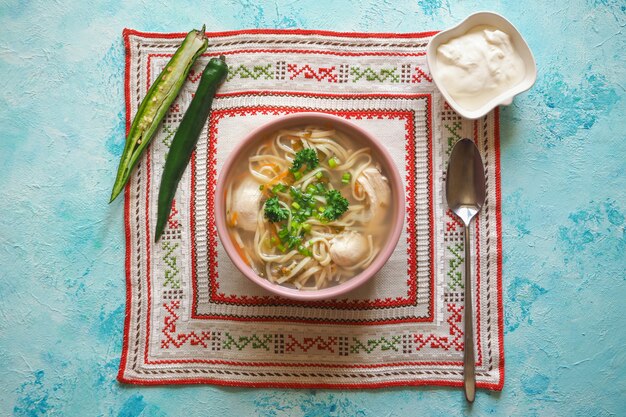 Canja de galinha Zama, romena e moldávia com macarrão. A tradicional sopa de ressaca é servida com pimenta e creme de leite.