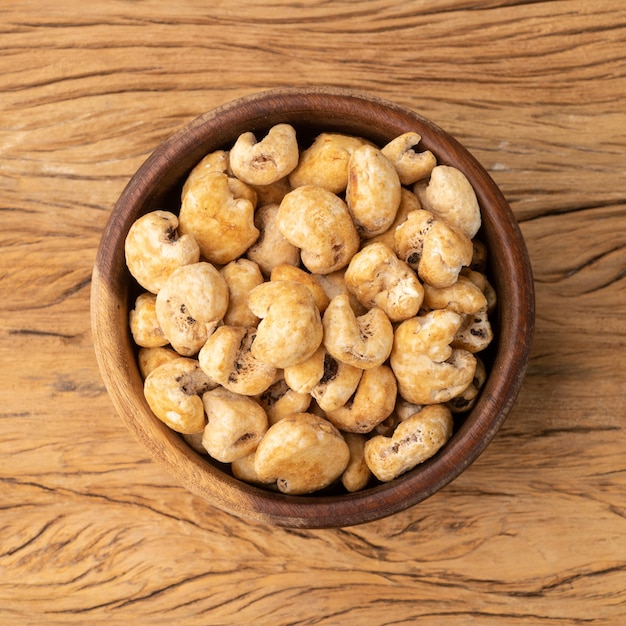 Canjica, maíz maíz o palomitas de maíz blanco, palomitas de maíz dulce en un recipiente sobre la mesa de madera.