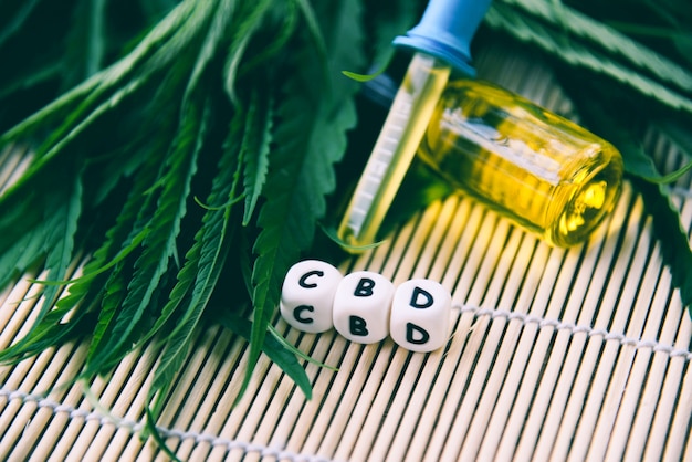 Cannabisöl in der flasche produkte aus holz hintergrund cbd öl cannabisblatt marihuana blätter für hanf medizinische gesundheitsversorgung