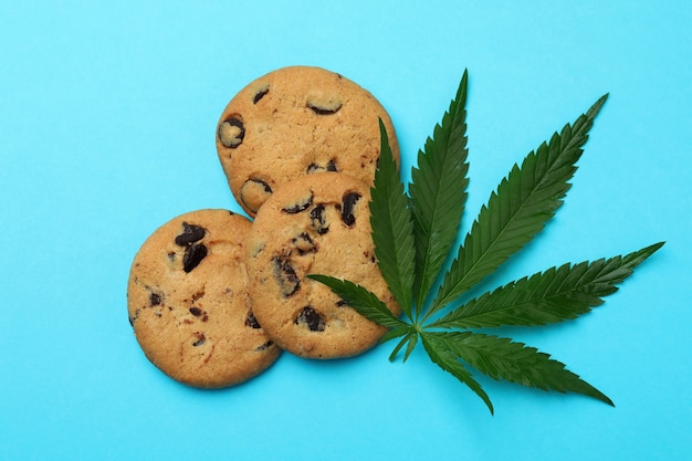 Cannabisplätzchen und Blatt auf blauem Hintergrund