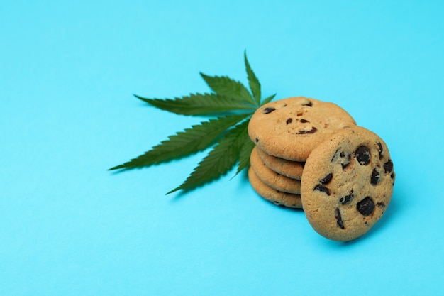 Cannabisplätzchen und Blatt auf blauem Hintergrund