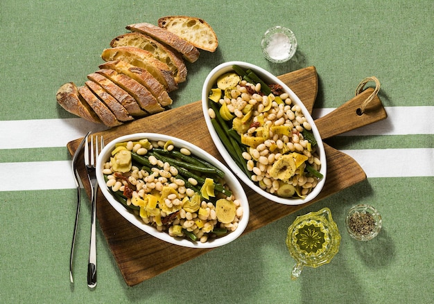 Cannellini nahrhafter weißer Bohnensalat mit grünen Bohnen sonnengetrockneten Tomaten und Artischocken in Öl Traditionelle italienische Küche