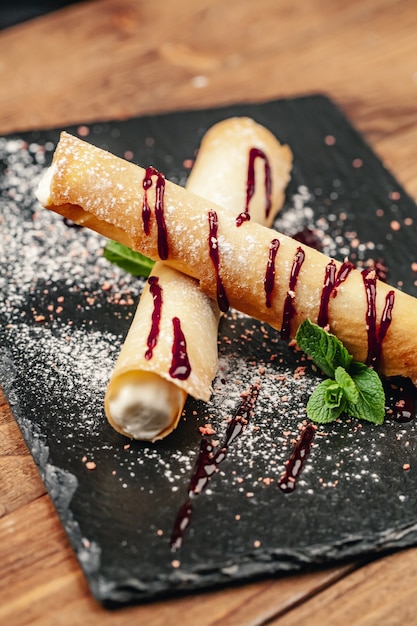 Cannoli con azúcar en placa negra